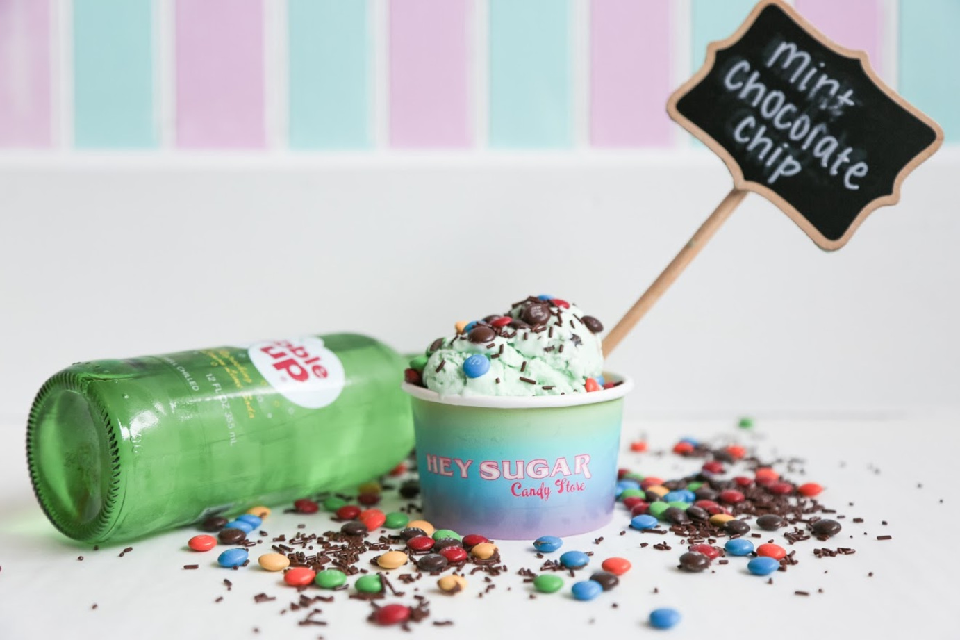 Ice cream with toppings, bottle in the background
