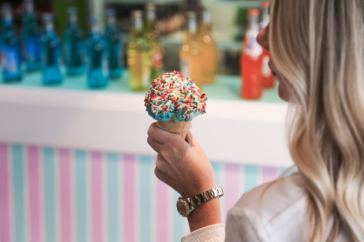The girl holds a multicolored ice cream in her hand